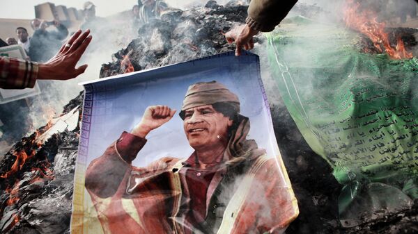 Жители Бенгази сжигают портреты Муамара Каддафи, плакаты с его цитатами и Зеленую книгу Каддафи