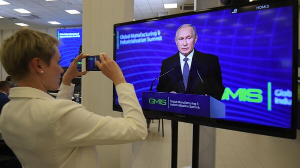 Журналист следит за выступлением президента РФ Владимира Путина на панельной дискуссии в рамках саммита GMIS-2019 в Екатеринбурге