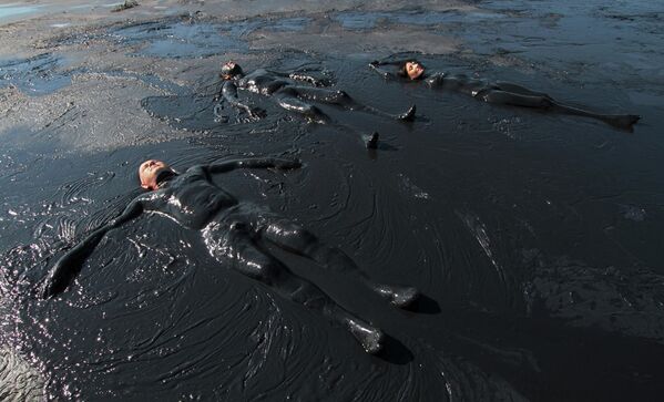 Отдыхающие принимают грязевые ванны на Чокракском озере в Крыму