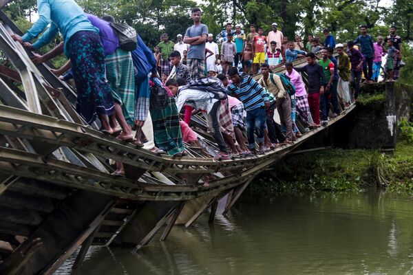 Пешеходы переходят сломанный мост в Силхете, Бангладеш 