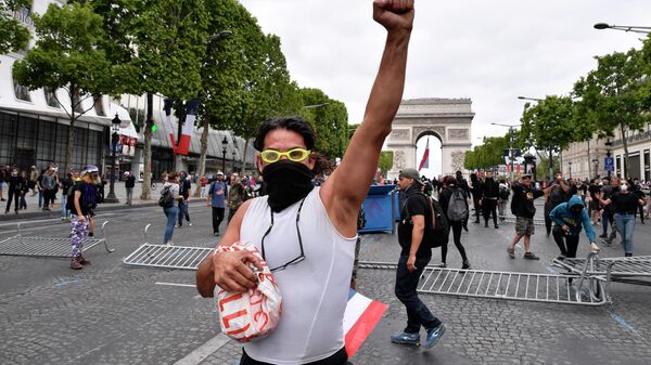 Участник беспорядков на Елисейских полях в Париже. 14 июля 2019