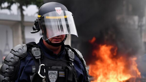 Полицейский во время протеста после парада в День взятия Бастилии в Париже, Франция. 14 июля 2019