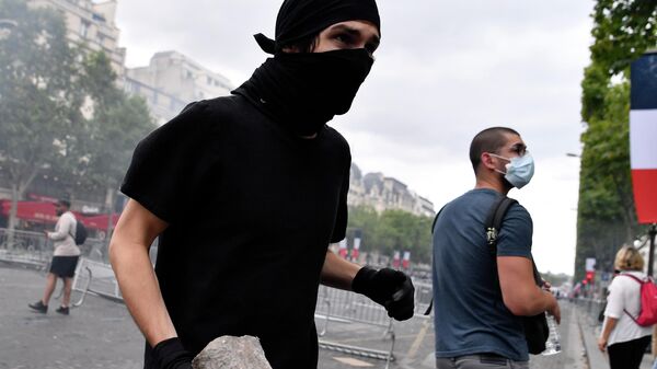 Участник беспорядков на Елисейских полях в Париже. 14 июля 2019