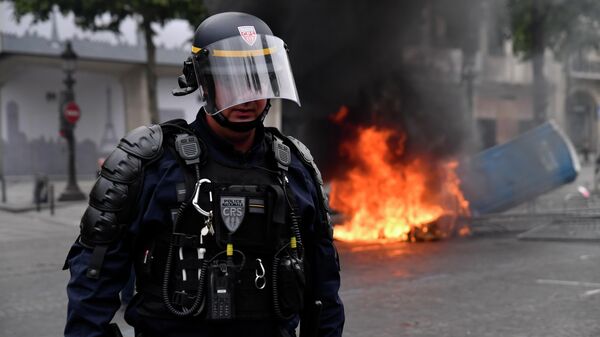 Сотрудник полиции во время беспорядков на Елисейских полях в Париже