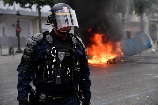 Сотрудник полиции во время беспорядков на Елисейских полях в Париже