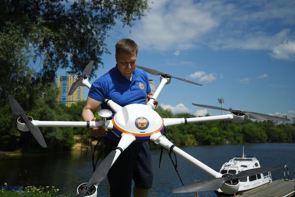 Спасатель демонстрирует беспилотный летательный аппарат на поисково-спасательной станции Строгино в Москве