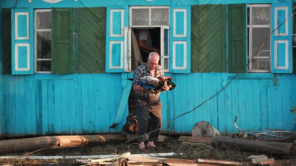 Местный житель возле разрушенного паводком дома в городе Тулун в Иркутской области