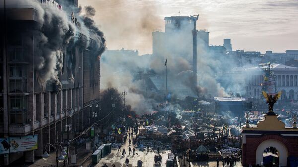 Дым от пожаров и сторонники оппозиции на площади Независимости в Киеве, где начались столкновения митингующих и сотрудников милиции