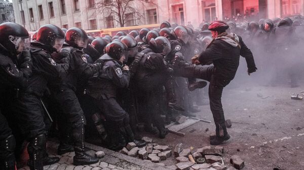 Участник акции сторонников евроинтеграции Украины перед строем сотрудников правоохранительных органов во время беспорядков возле здания Администрации президента Украины на Банковой улице в Киеве