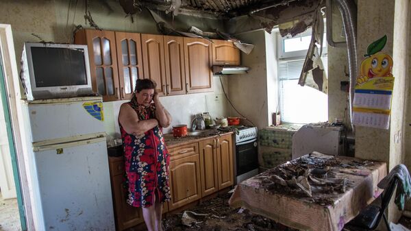 Женщина в своем доме, пострадавшем в результате ночного артобстрела со стороны украинских военных на окраине Славянска