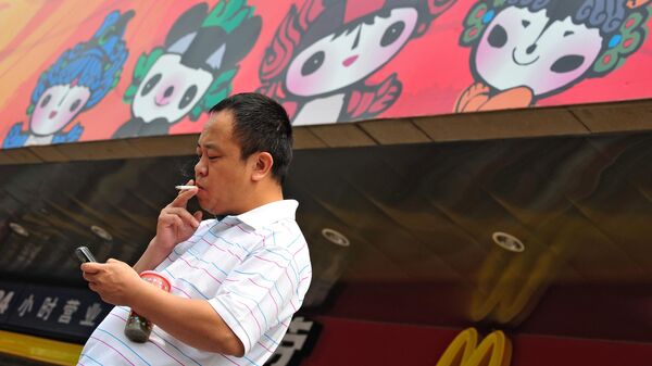 Мужчина курит на Олимпийских играх в Пекине