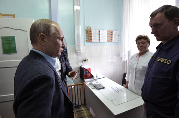 Президент РФ Владимир Путин во время осмотра медицинского кабинета в пункте размещения пострадавшего в результате наводнения населения. 19 июля 2019