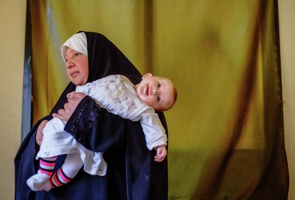 Женщина с ребенком - беженцы из Сирии - в одном из домов в городе Хальба на севере Ливана