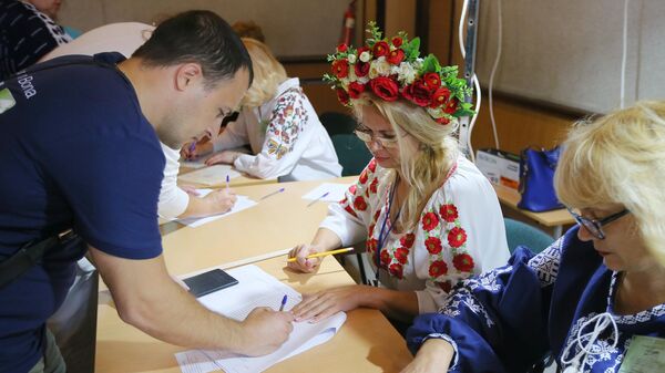 Мужчина расписывается в списке избирателей на участке в Киеве на досрочных выборах в Верховную раду Украины