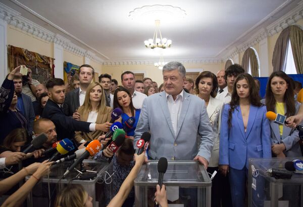 Экс-президент Украины Петр Порошенко общается с журналистами на избирательном участке в Киеве, после того как проголосовал на досрочных выборах в Верховную раду Украины