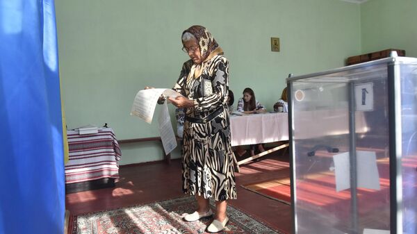 Женщина  голосует на досрочных выборах в Верховную раду Украины на избирательном участке в селе Фийна Львовской области