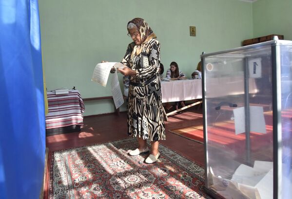 Женщина  голосует на досрочных выборах в Верховную раду Украины на избирательном участке в селе Фийна Львовской области