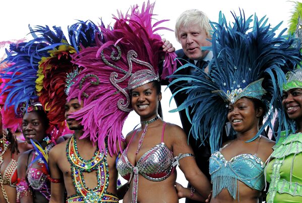 Мэр Лондона Борис Джонсон позирует с танцорам во время карнавала в Ноттинг Хилле. 24 августа 2011 года
