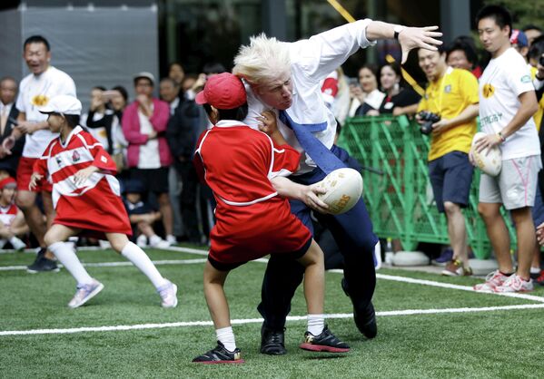 Мэр Лондона Борис Джонсон во время игры в регби с детьми в Токио. 15 октября 2015 года