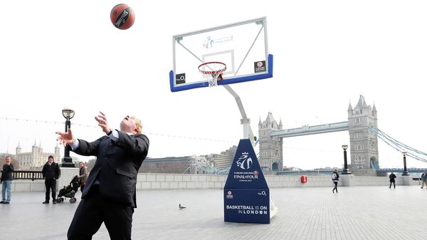 Мэр Лондона Борис Джонсон забивает мяч в корзину в Лондоне. 8 апреля 2013 года