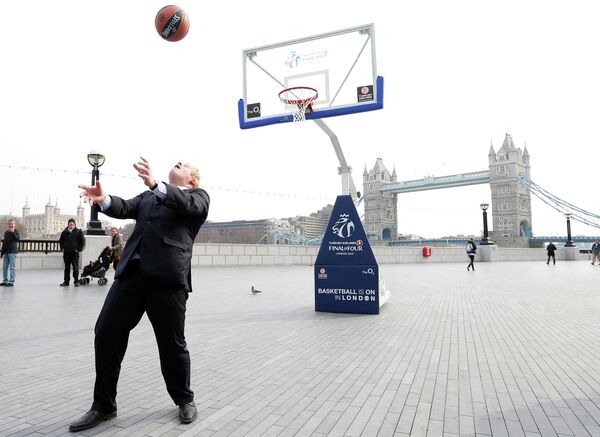 Мэр Лондона Борис Джонсон забивает мяч в корзину в Лондоне. 8 апреля 2013 года