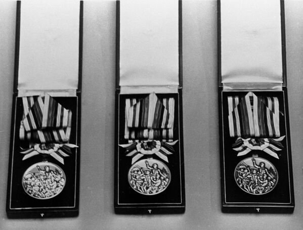 Медали XVIII Олимпиады в Токио - золотая, серебряная, бронзовая.