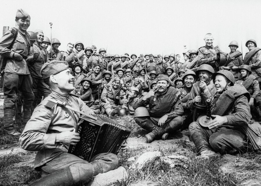 Советские бойцы слушают игру гармониста
