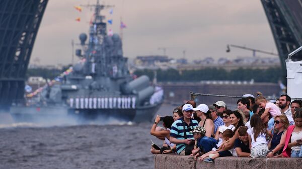 Зрители наблюдают за проходом кораблей по Неве на главном военно-морском параде, посвященном Дню ВМФ в Санкт-Петербурге