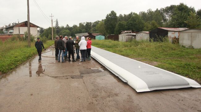 Сотрудники МЧС разворачивают водоналивную дамбу