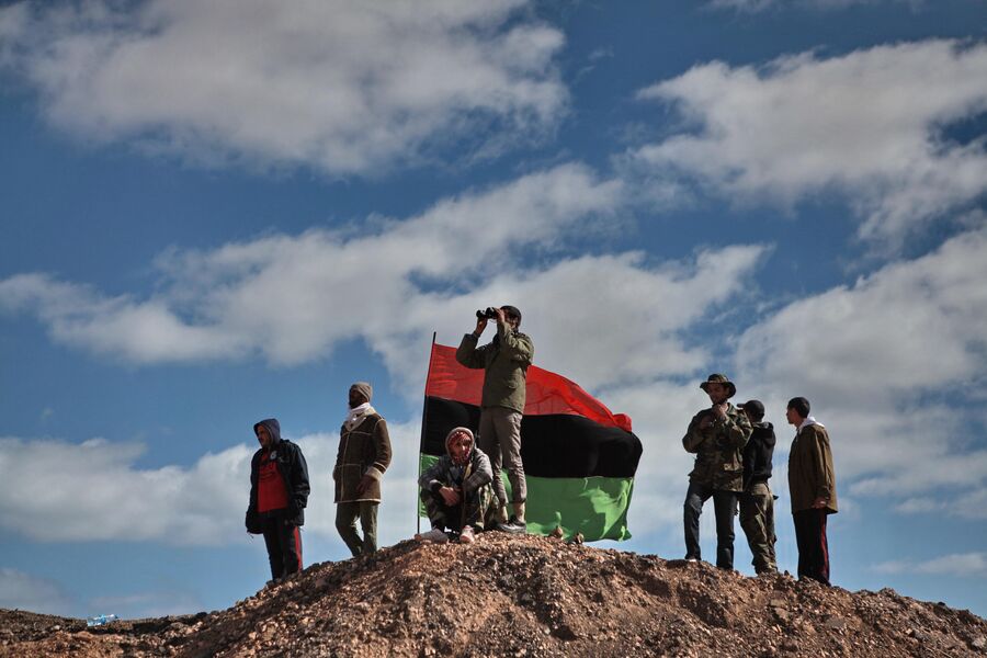 Бойцы оппозиции наблюдают с холма за боем за ходом боев за город Бин-Джавад