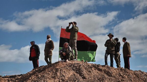 Бойцы оппозиции наблюдают с холма за боем за ходом боев за город Бин Джавад