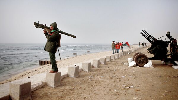 Боец сил самообороны Бенгази с переносной зенитной установкой стоит на набережной Средиземного моря
