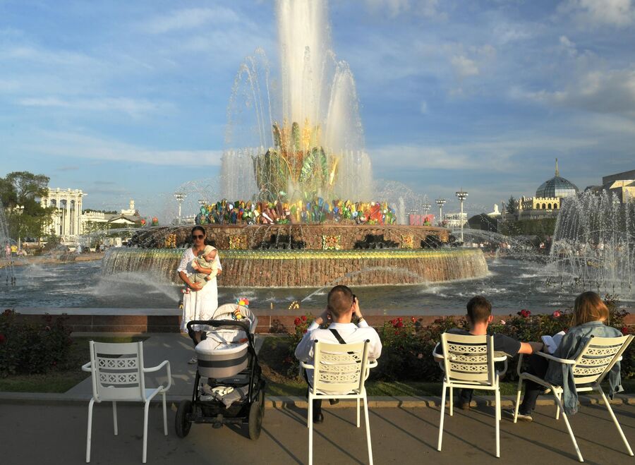 Люди отдыхают у фонтана Каменный цветок на ВДНХ в Москве