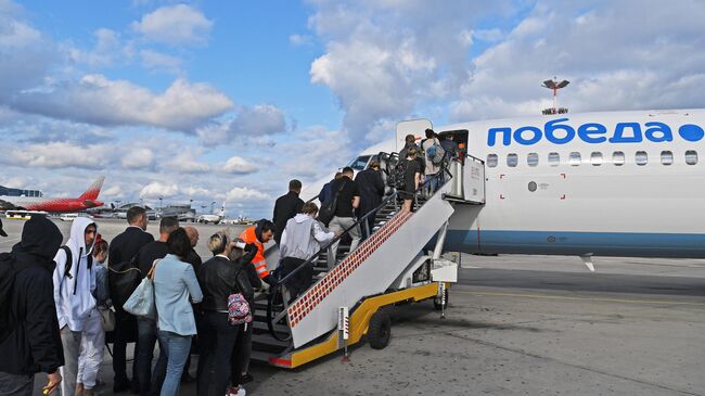 Пассажиры проходят на посадку в самолет авиакомпании Победа в аэропорту Внуково