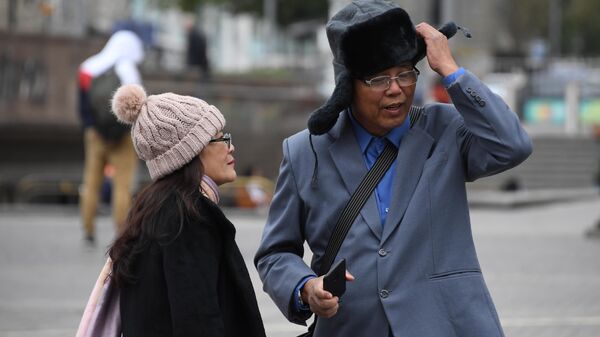 Иностранные туристы, одевают теплые головные уборы, на Манежной площади