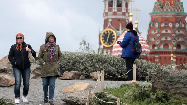 Жители Москвы, одетые в осенние куртки, в парке Зарядье