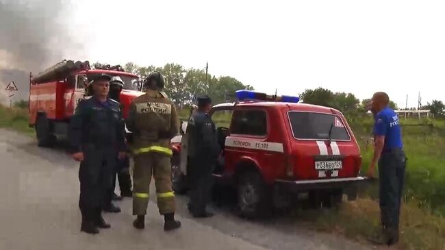 Сотрудники МЧС в районе воинской части под Ачинском, где произошли пожар и взрывы на складе хранения артиллерийских боеприпасов. Стоп-кадр с видео