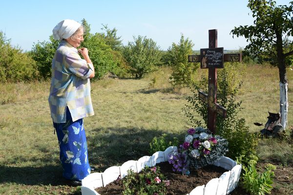Женщина у мемориального креста на месте гибели фотокорреспондента Международного информационного агентства Россия сегодня Андрея Стенина