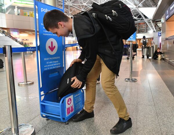 Пассажир использует калибратор багажа возле стойки регистрации авиакомпании Победа в аэропорту Внуково имени А. Н. Туполева