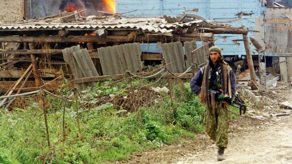 Военнослужащий МВД Дагестана ищет оставшихся исламских боевиков в дагестанском селе Карамахи. 16 сентября 1999 года