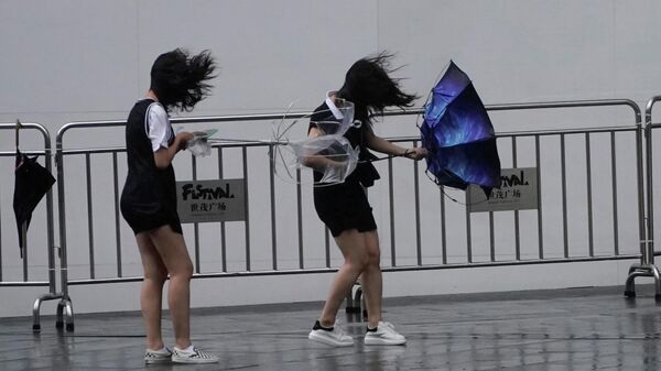 Девушки во время прохождения супертайфуна Лекима в Шанхае, КНР. 10 августа 2019