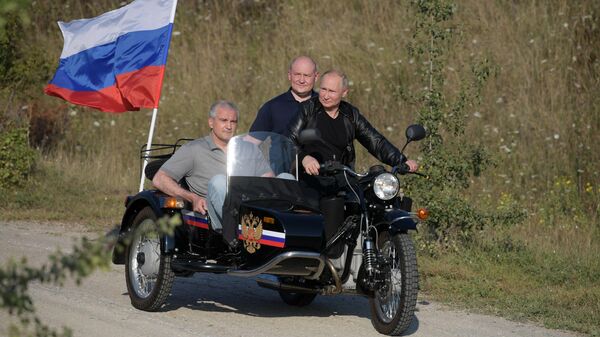Президент Владимир Путин за рулем мотоцикла Урал с коляской на международном байк-шоу Тень Вавилона в Севастополе. 10 августа 2019