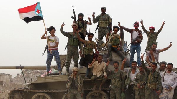 Члены поддерживаемых ОАЭ южно-йеменских сепаратистских сил стоят на танке во время столкновений с правительственными войсками в Адене, Йемен