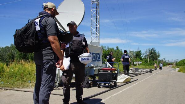 Представители ОБСЕ, прибывшие для наблюдения за первым этапом отвода украинских подразделений, в районе пропускного пункта Станица Луганская