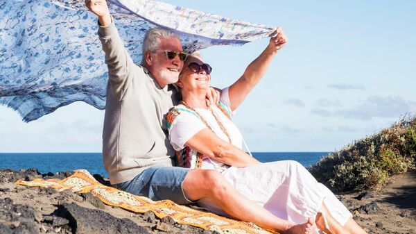 Пожилая пара отдыхает на берегу океана на Тенерифе