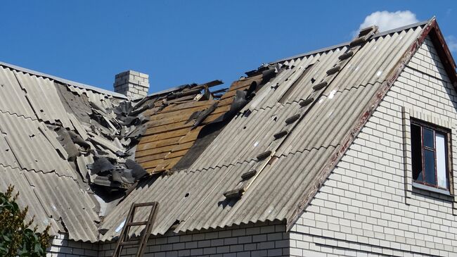 Разрушенная крыша дома в результате обстрела украинскими силовиками частного сектора села в Донбассе