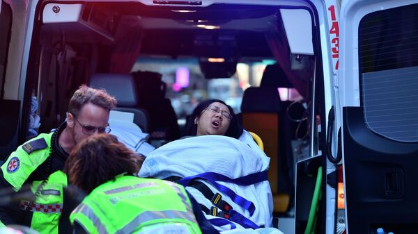 Машина скорой помощи забирает женщину из отеля CBD на углу улиц Кинг и Йорк в Сиднее, Австралия. 13 августа 2019