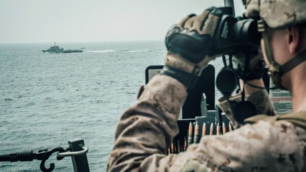 Морской пехотинец США наблюдает за иранским кораблем c американского военного корабля USS John P. Murtha  во время транзита через Ормузский пролив 