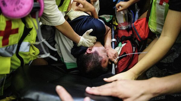 Мужчина окруженный и раненый демонстрантами в международном аэропорту Гонконга, подозревавшими его в том, что он является сотрудником полиции континентальной части Китая. 14 августа 2019