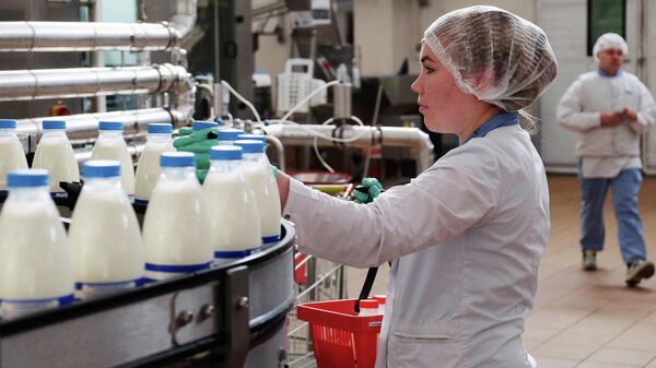 Сотрудница на производственной линии по упаковке молока на молочном заводе Danone в Самаре